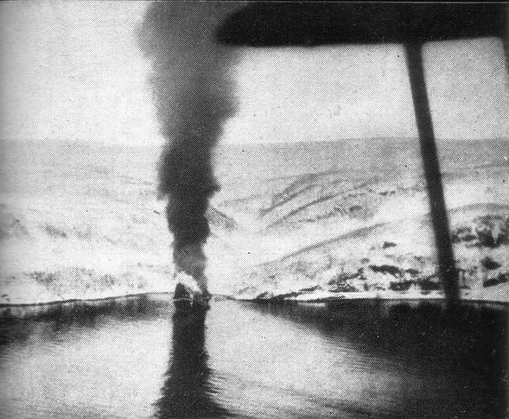 narvik3.jpg - Beached against the snow-covered rocks of Herjangs Fiord, the same destroyer burns herself out. Swordfish struts are outlined in the foreground.